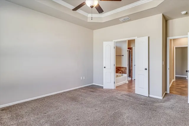 an empty room with a ceiling fan and a window