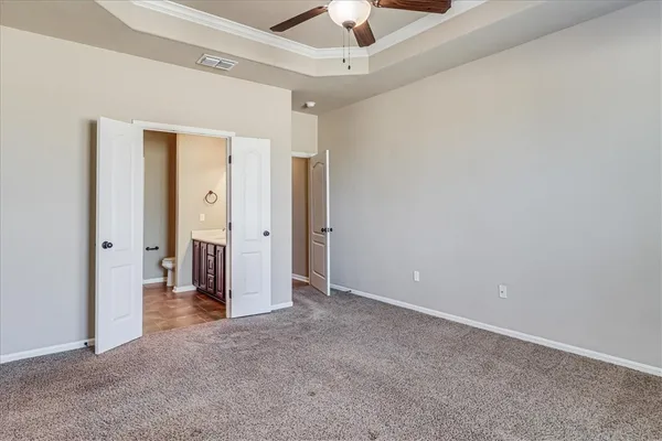 an empty room with closet and a chandelier fan