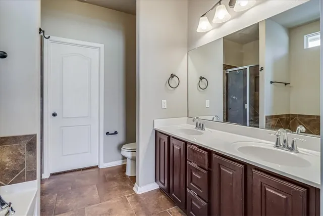 a bathroom with a double vanity sink and a toilet