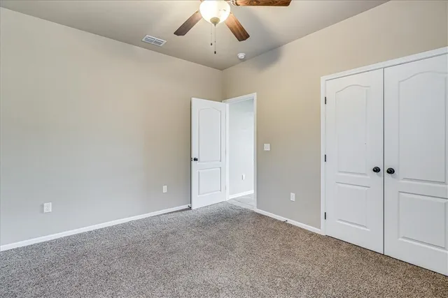 an empty room with windows and closet