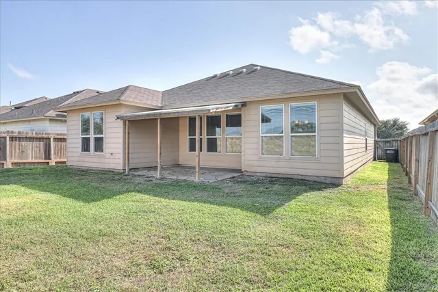a view of a yard in front of a house with large windows