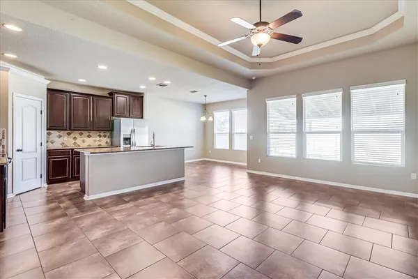 a view of kitchen with granite countertop cabinets and window