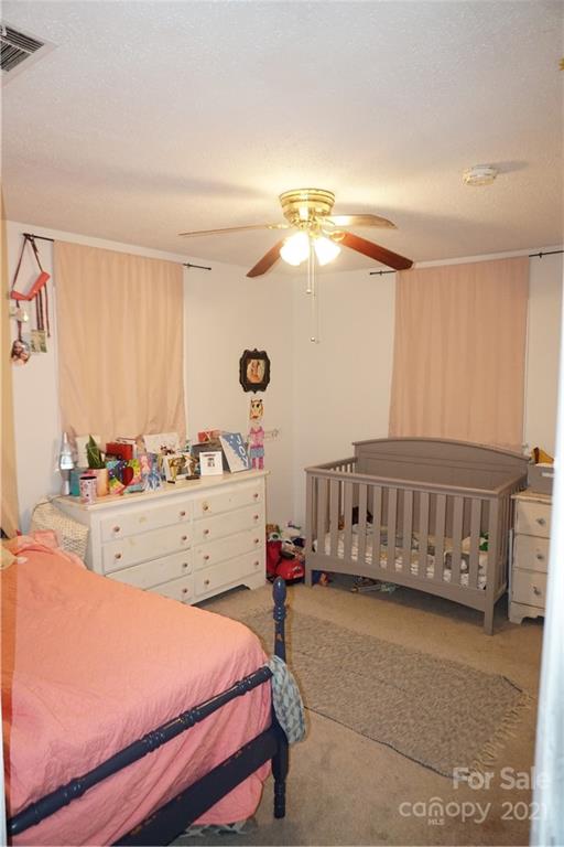 10441 Rockwood Road Charlotte, NC 28215 - Photo 44 of 45 a bedroom with a bed and a chandelier