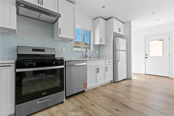 a kitchen with stainless steel appliances a stove a sink and a refrigerator