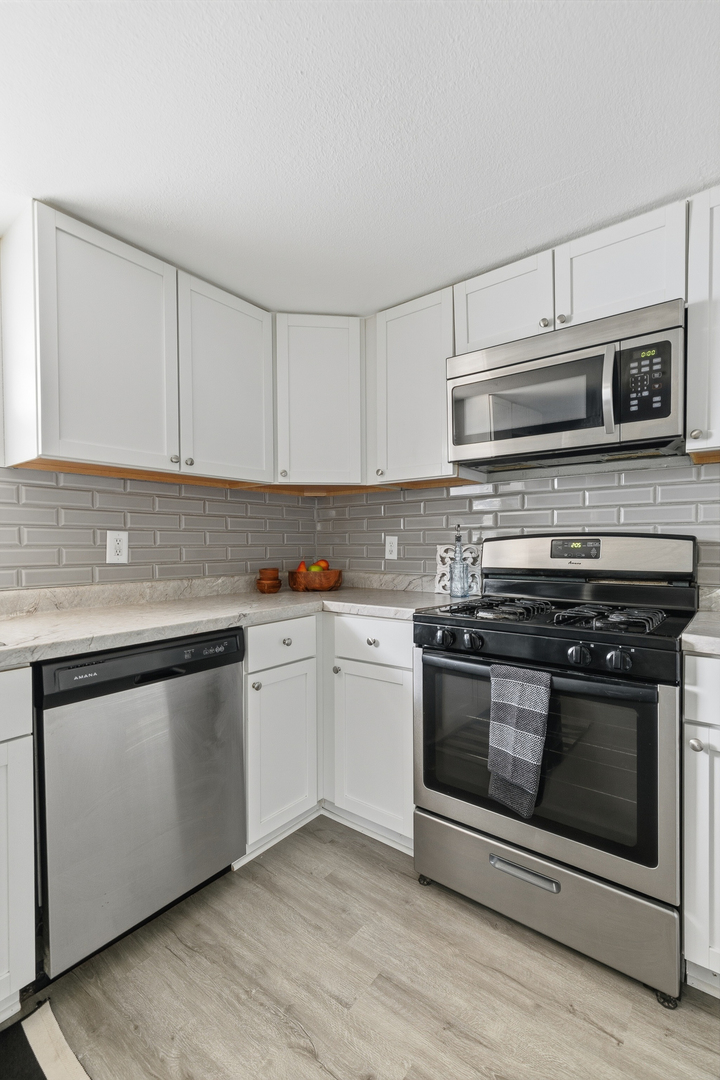 2306 9th Street Silvis, IL 61282 - Photo 17 of 32 a kitchen with stainless steel appliances granite countertop a stove and a sink