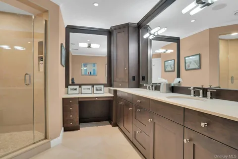 a bathroom with a double vanity sink mirror and shower