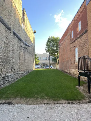 a view of a back yard of the building with a yard