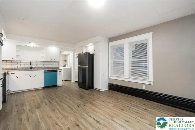 a kitchen with granite countertop a refrigerator stove top oven and sink