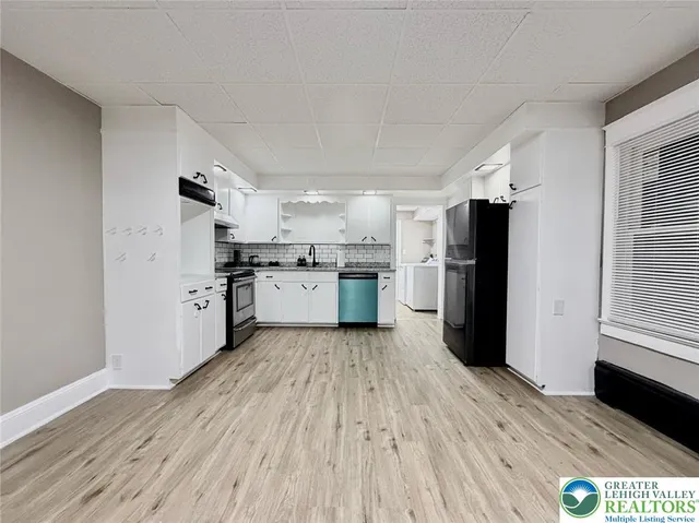 a kitchen with stainless steel appliances a sink cabinets and wooden floor