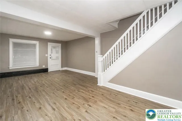 a view of a hallway with wooden floor and staircase