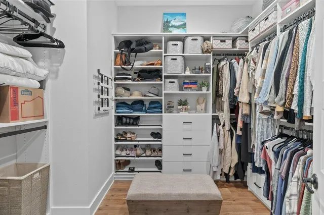 a view of walk in closet with clothes and shoes
