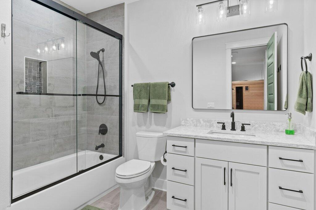 34 Caymus Cove Freeport, FL 32439 - Photo 35 of 42 a bathroom with a toilet a sink a glass door a shower a mirror a vanity and window