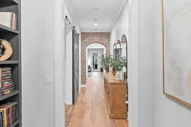a view of a hallway with wooden floor and furniture