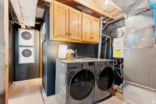 11237 East Aspen Road, Unit 74 Heber City, UT 84032 - Photo 24 of 32 Dedicated laundry area featuring a front-loading washer and dryer set, wood-finish upper cabinetry, and a tankless water heater