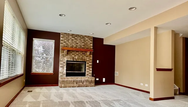 a view of an empty room with a fireplace and a window