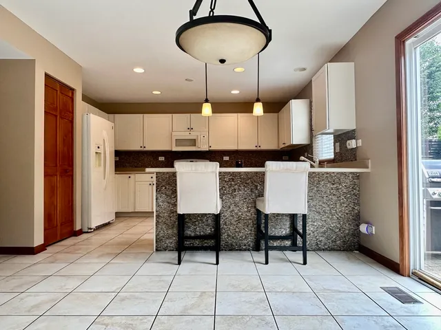 a kitchen with kitchen island granite countertop a stove a sink and a refrigerator