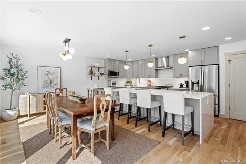 a kitchen with kitchen island a dining table and chairs