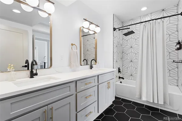 a bathroom with a double vanity sink mirror and shower