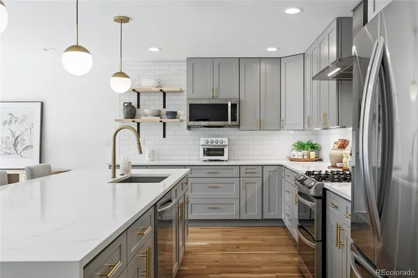 a kitchen with stainless steel appliances granite countertop a sink a stove and a refrigerator