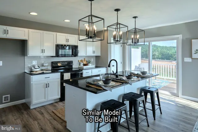 a kitchen with stainless steel appliances granite countertop a stove top oven a refrigerator a sink and a dining table with wooden floor