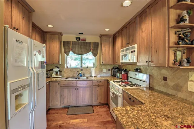 a kitchen with stainless steel appliances a refrigerator sink and cabinets