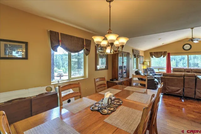 a living room with dining table and a chandelier