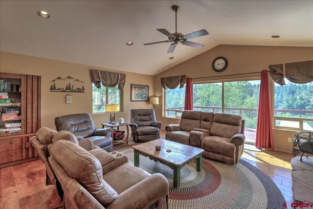 a living room with furniture a flat screen tv and a large window