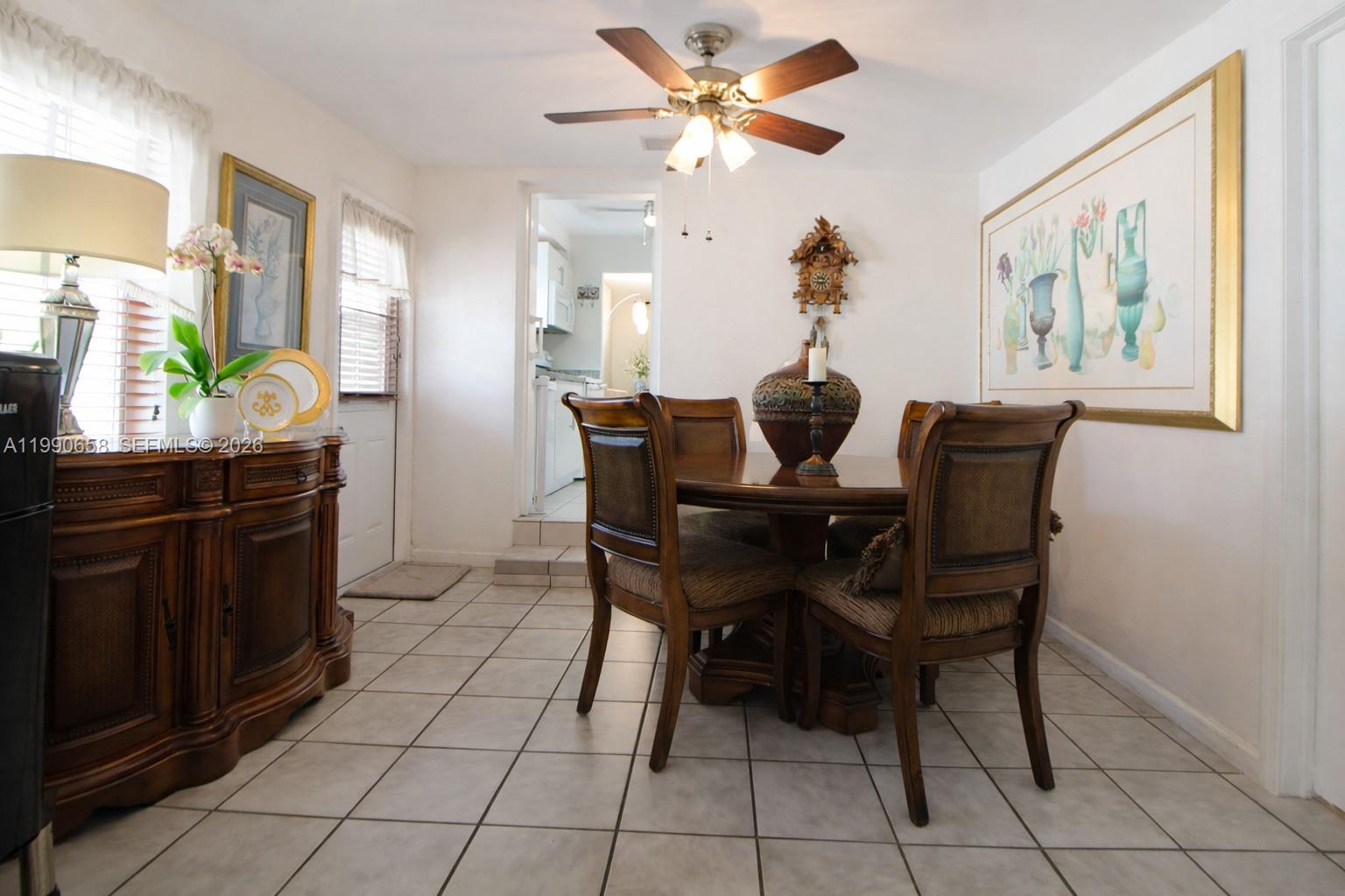 2314 Southwest 60th Avenue Miami, FL 33155 - Photo 11 of 45 a dining room table chairs and a chandelier fan