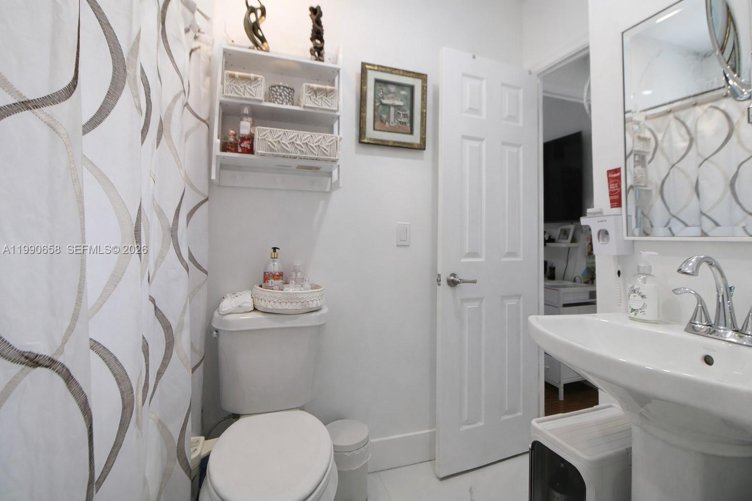 2314 Southwest 60th Avenue Miami, FL 33155 - Photo 13 of 45 a bathroom with a sink a toilet and a mirror