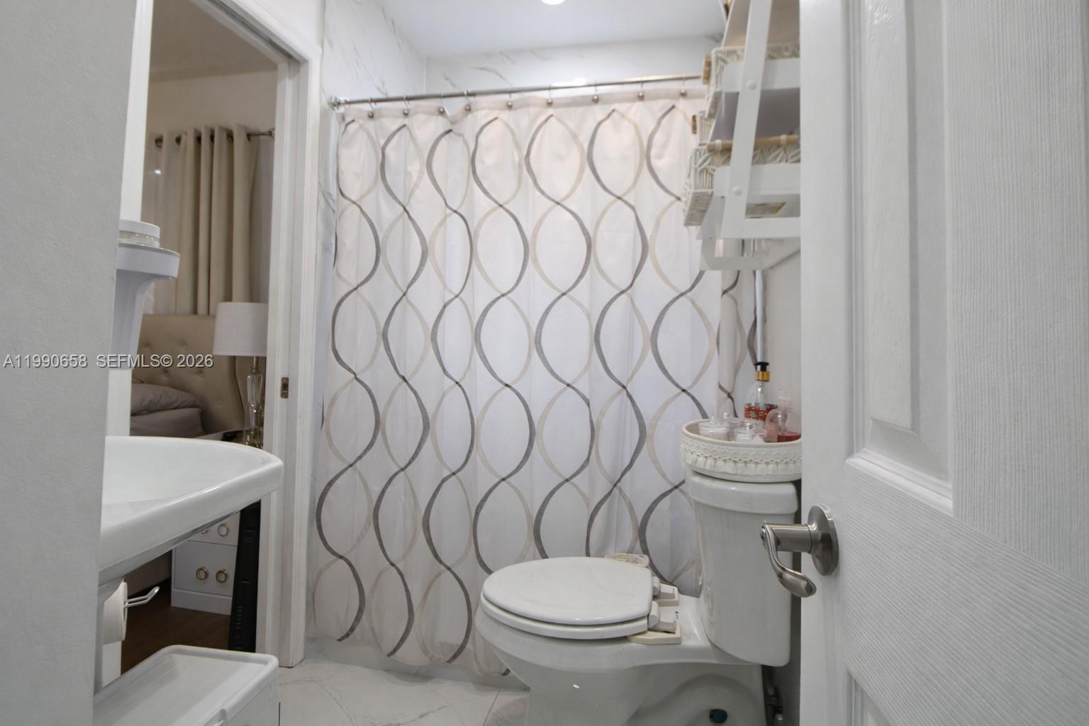 2314 Southwest 60th Avenue Miami, FL 33155 - Photo 14 of 45 a bathroom with a toilet and shower curtain