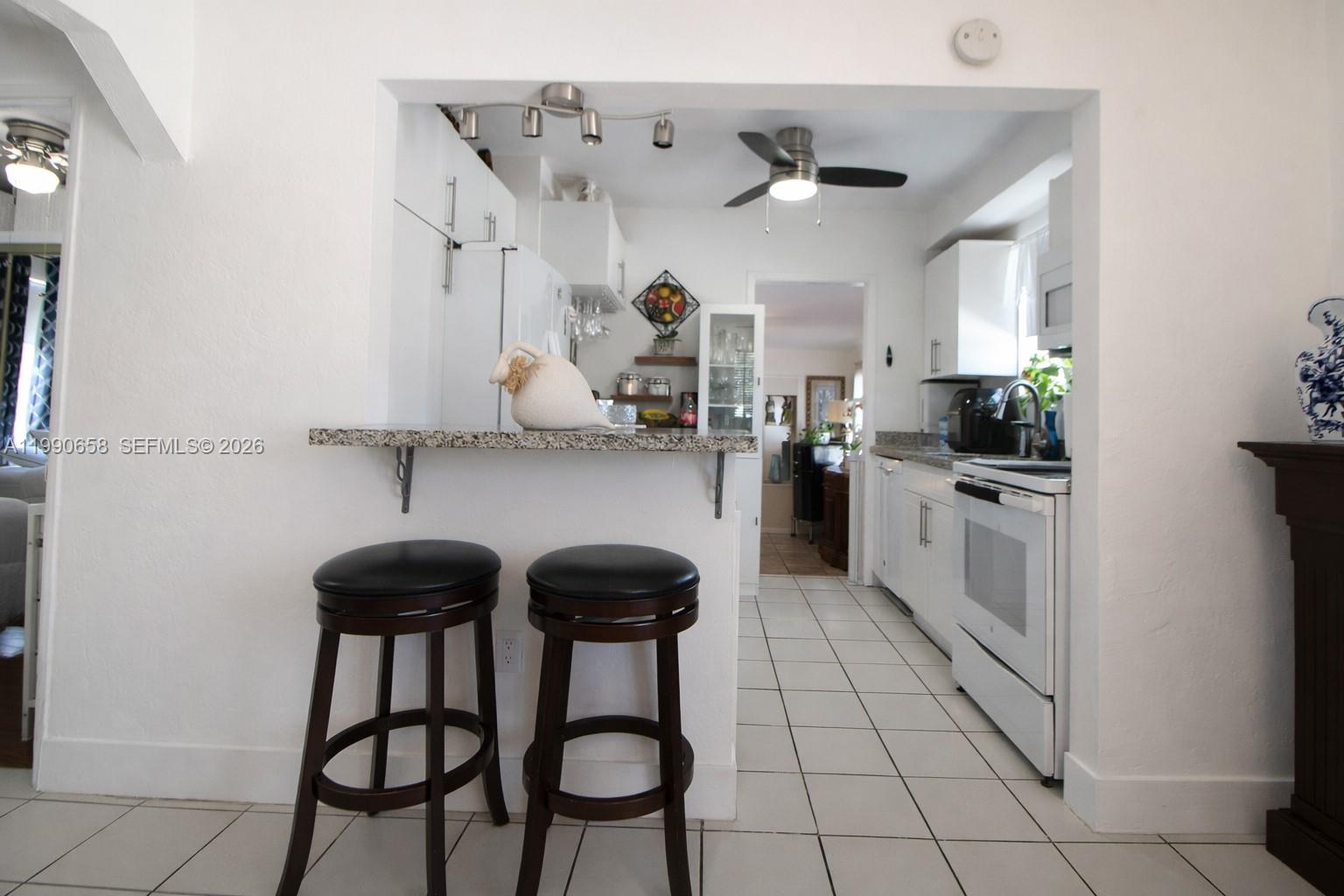 2314 Southwest 60th Avenue Miami, FL 33155 - Photo 8 of 45 a kitchen with stainless steel appliances kitchen island granite countertop a sink and cabinets