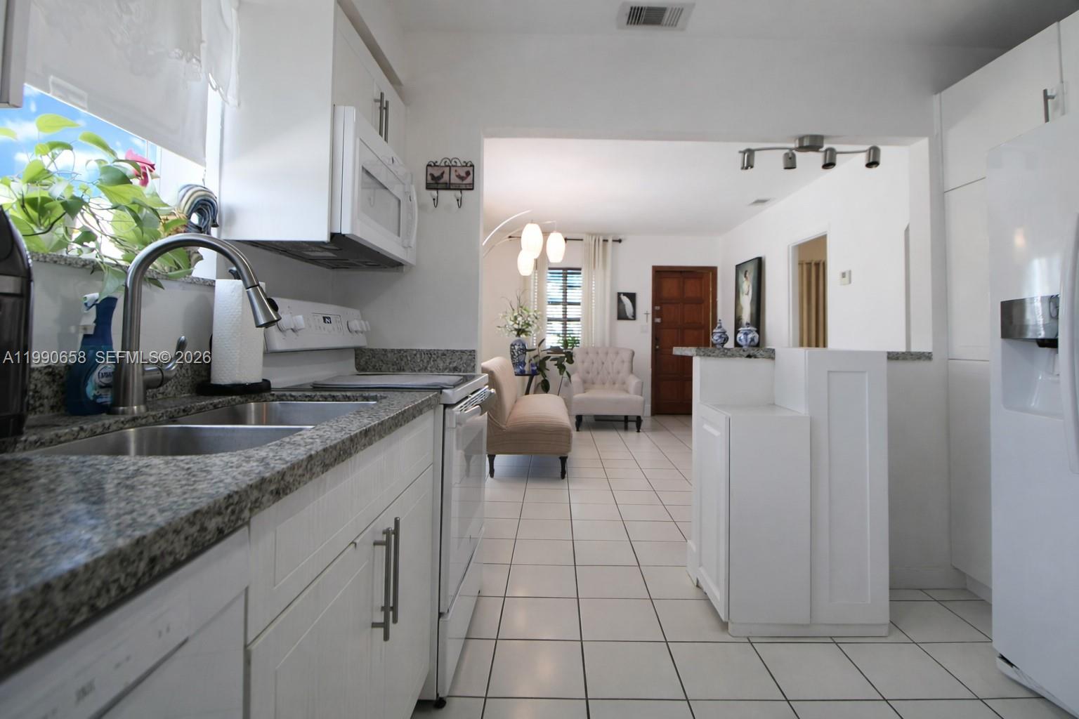 2314 Southwest 60th Avenue Miami, FL 33155 - Photo 9 of 45 a kitchen with stainless steel appliances granite countertop a sink a stove top oven a counter space and cabinets