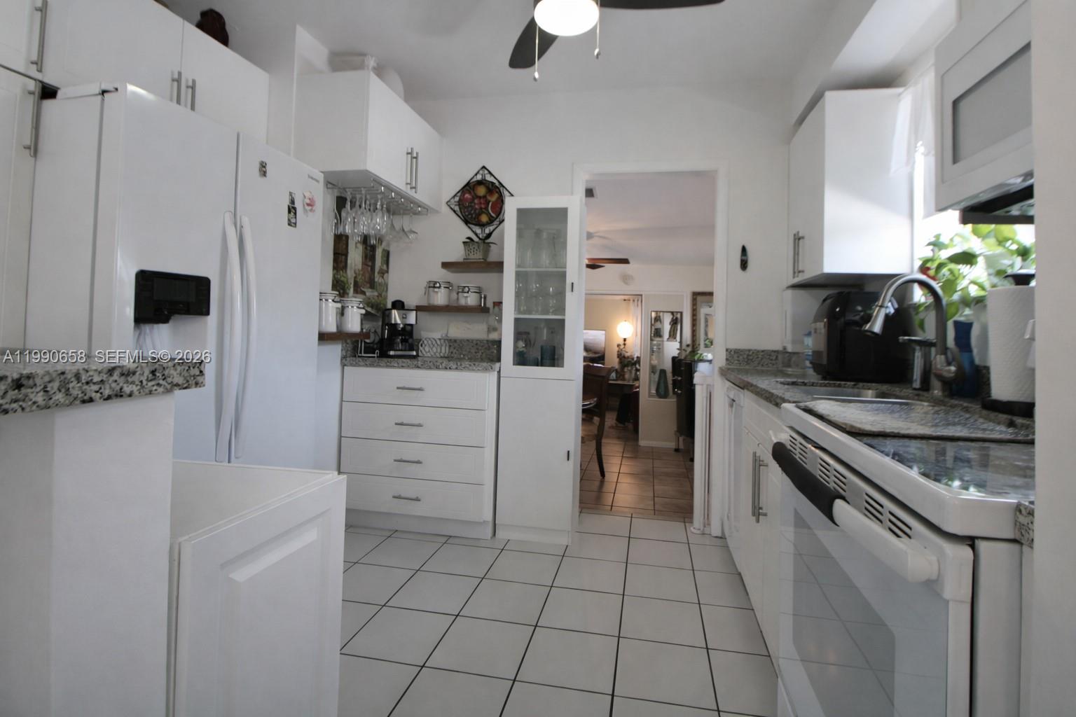2314 Southwest 60th Avenue Miami, FL 33155 - Photo 10 of 45 a kitchen with a stove a sink and a refrigerator