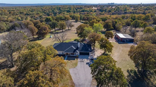 an aerial view of house with yard and mountain view in back