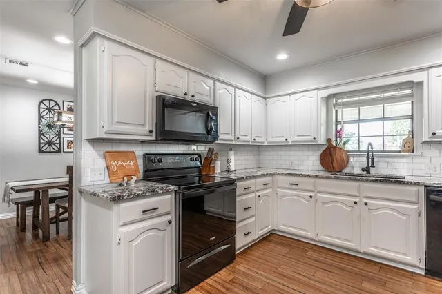 a kitchen with kitchen island granite countertop a sink cabinets and stainless steel appliances