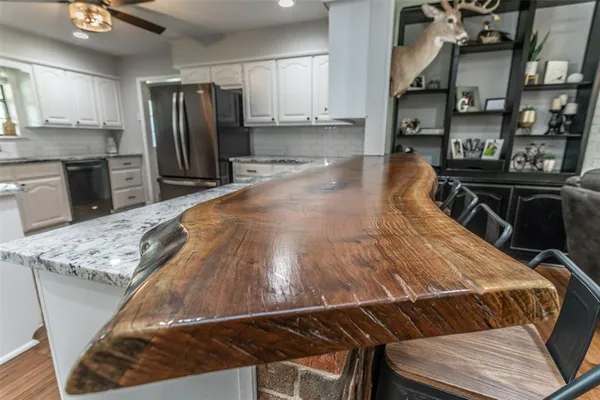 a view of a kitchen with kitchen island a sink appliances and cabinets