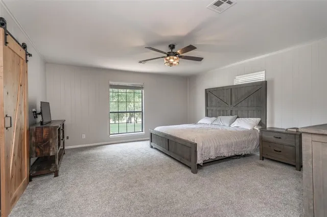 a bedroom with a bed and a ceiling fan