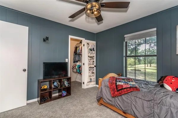a bedroom with furniture and a flat screen tv