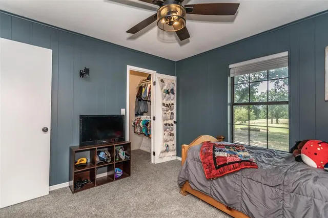 a bedroom with furniture and a flat screen tv