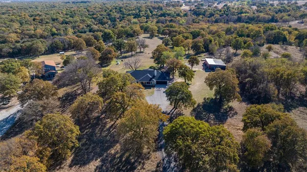 an aerial view of residential houses with outdoor space and trees