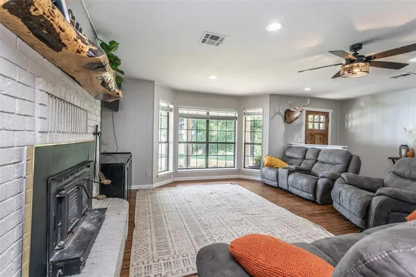 a living room with furniture a fireplace and a large window