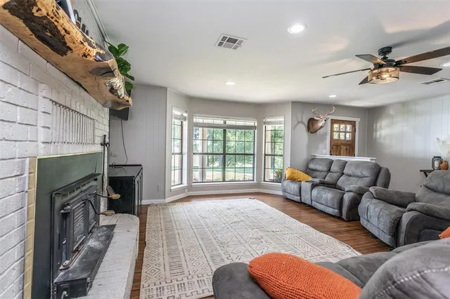 a living room with furniture a fireplace and a large window