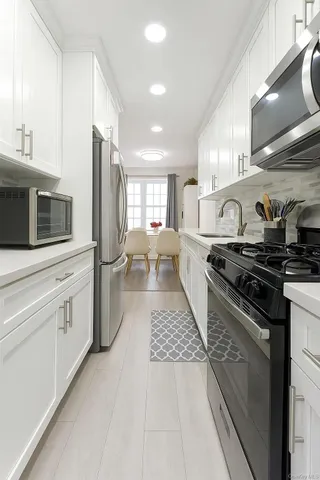 a kitchen with stainless steel appliances kitchen island granite countertop a stove a sink and a refrigerator
