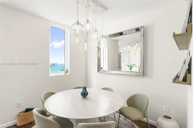 a view of a living room with a floor to ceiling window and wooden floor