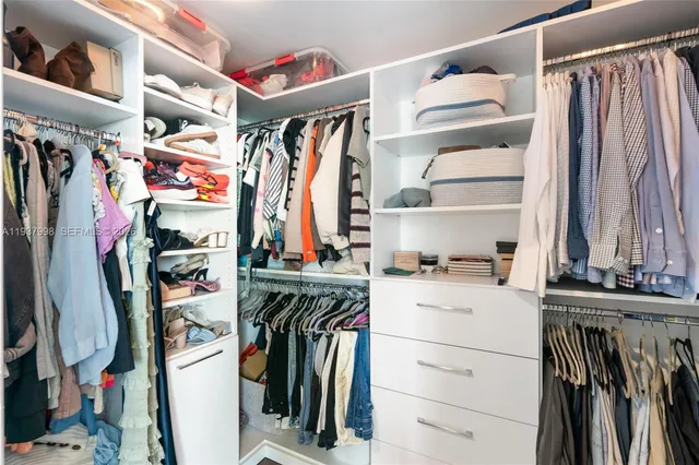 a bedroom with a bed potted plant on dresser and a flat screen tv