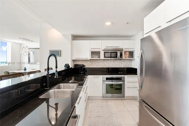 a kitchen with stainless steel appliances granite countertop a stove and a microwave
