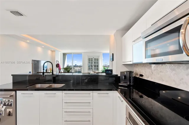 a living room with furniture large windows and wooden floor