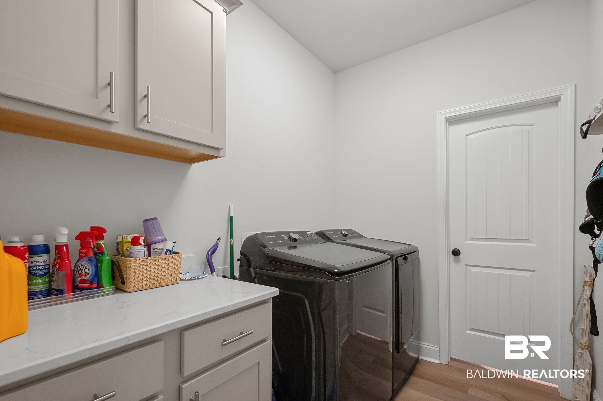 1165 Stella Road Foley, AL 36535 - Photo 29 of 42 Laundry room featuring washing machine and dryer, light wood finished floors, cabinet space, and baseboards