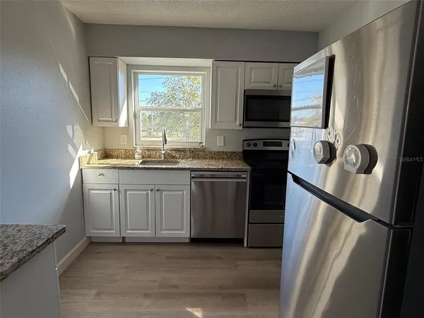 a kitchen with a sink stove and refrigerator