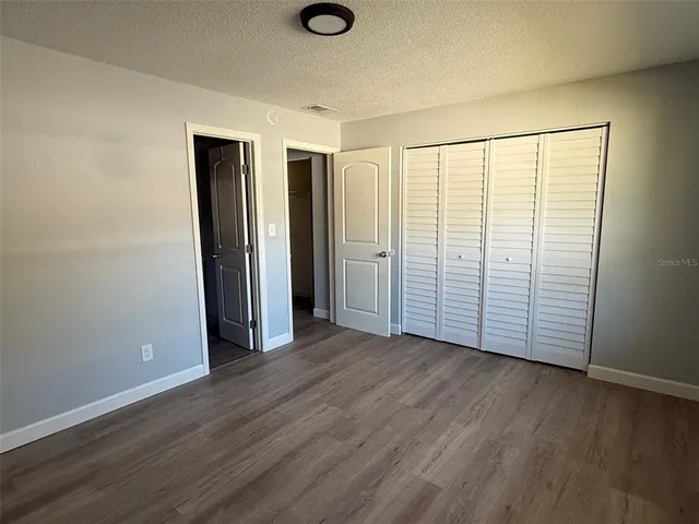 an empty room with wooden floor and closet